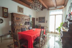 威尼斯Casa Eden的一间用餐室,配有红色的桌子和椅子