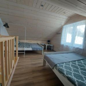 Tyrawa WołoskaDomek Zacisze Gór Słonnych的小木屋内带两张床的房间