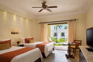图卢姆Dreams Tulum Resort & Spa的酒店客房设有两张床和电视。