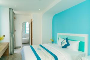 头顿La Casa Boutique Hotel的卧室配有蓝色和白色的床和浴缸。