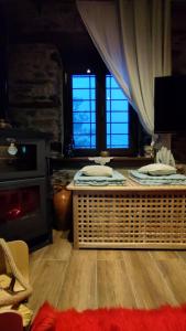 基索斯Ο ξενώνας της Πίτσαινας的客厅配有桌子和2扇窗户