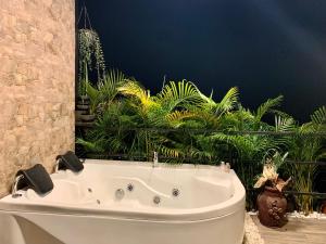 PalestinaVerdes Hábitat Glamping的浴室设有白色浴缸,种植了植物。