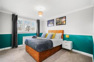 WhittlesfordStunning Cambridge Abode - Garden - Pet Friendly的一间卧室设有一张床和绿色的墙壁