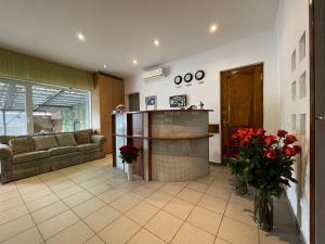 基辅古萨斯凯酒店及公寓的客厅配有沙发和红色鲜花桌