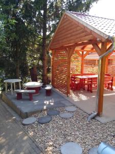 比克克塞克Gesztenyes Vendeghaz的木制凉亭,配有野餐桌和长椅