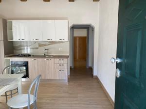 帕尔盖利亚Appartamento da Antonio的厨房配有白色橱柜和绿门