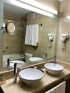 韦林格勒Maxi Park Hotel & Spa的一间带两个盥洗盆和大镜子的浴室