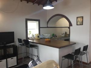 AlmagrinhaCasa Malbusca的厨房配有带凳子和桌子的柜台