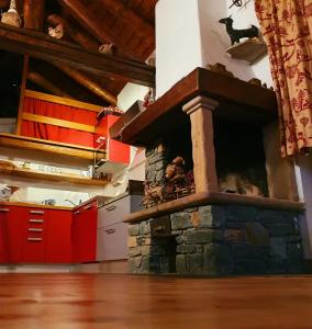 瓦托内切CHALET DI MONTAGNA, Valtournenche-Cervinia的带红色橱柜的厨房内的石头壁炉