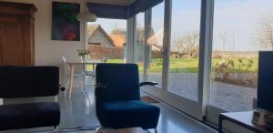 ErmErmerhoek, in de Hof的客房设有桌椅和大窗户。