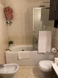 菲乌米奇诺AGM Suite Rome Airport FCO - Attico Parco Leonardo的带浴缸、卫生间和盥洗盆的浴室