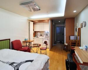 首尔克汉公寓的一间卧室配有一张床,厨房配有桌子