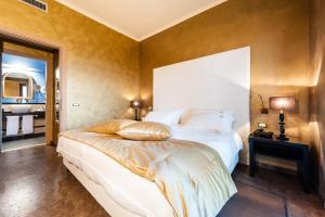 维泰博Alla Corte Delle Terme Resort的卧室配有一张白色大床和镜子