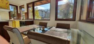 索非亚ALBISTO Dragalevtsi Luxury Apartments的厨房里设有玻璃桌的用餐室