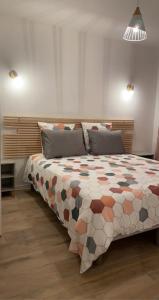 AussonneMEET - AIRBUS - TRAMWAY的一间卧室配有一张大床和色彩缤纷的被子