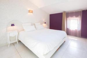 圣佩赖心藤旅馆的卧室设有一张白色大床和一扇窗户。