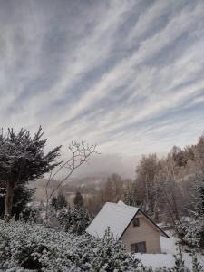 PieszyceDomek Na Leśnym Wzgórzu的屋顶上积雪的房子
