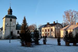 瓦斯泰纳Vadstena innerstad的一座在庭院中建有钟楼和树木的建筑