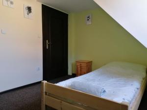 赫鲁别舒夫RESTAURACJA & PENSJONAT SZAMANKO的一间卧室设有一张床和一个黑色的门