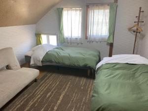 中富良野町Akane-yado的一间卧室配有两张床和一张沙发。