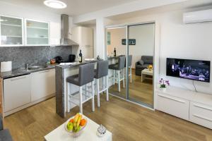 苏博蒂察MB Apartment 2的厨房以及带白色橱柜和电视的客厅。
