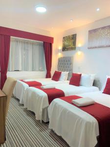 达特福德Green View Hotel的酒店客房,设有4张铺有红白床单的床