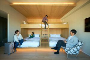 熊本FAV HOTEL KUMAMOTO的一组人在带双层床的房间里