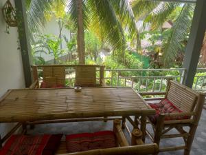 西塔努sweet home phangan的门廊配有2把椅子和木桌
