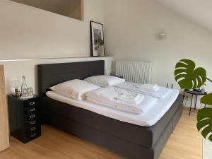 梅尔斯堡Ferienwohnung I Ferienhaus am Bodensee I Meersburg I Sauna I Fitness的卧室内的一张带白色床单和枕头的床