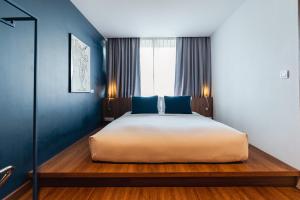 清迈QUU HOTEL Chiang Mai的一间卧室配有一张带蓝色墙壁的大床