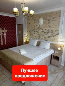 克拉斯诺达尔Квартира в ЖК Центральный на Буденного的一间卧室设有一张带砖墙的大床