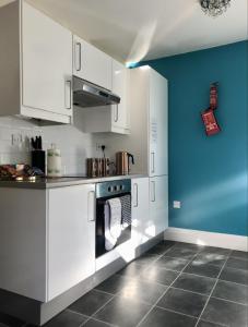 切姆Tudors的厨房配有白色橱柜和蓝色的墙壁