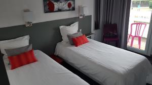 勒波日勒波尔格酒店 的两张位于酒店客房的床铺,配有红色枕头