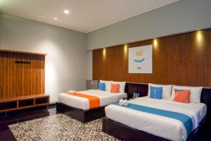 三宝垄Sans Hotel Empress Simpang Lima的酒店客房设有两张床和窗户。