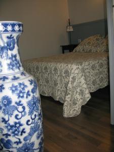 楠蒂阿南蒂阿之家穆布雷斯因-朱拉一室公寓的蓝色和白色的花瓶,坐在床边