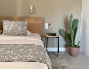 桑帕克StayMenorca Escapa a la naturaleza的一间卧室配有一张床和盆栽植物