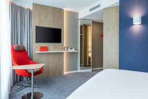 阿尔梅勒Holiday Inn Express - Almere, an IHG Hotel的酒店客房设有红色椅子和电视