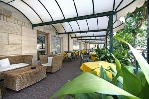 里米尼Hotel Aron的带沙发、桌椅和植物的天井