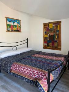 奥斯塔Chèvres à Cheval - Apartment的卧室配有一张床,墙上挂有绘画作品