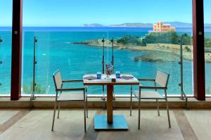 阿尔盖罗Smy Carlos V Wellness & Spa Alghero的桌椅,享有海景