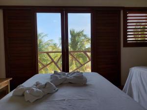 普雷亚Villa Aracoara的一间卧室配有一张床,享有棕榈树的景色