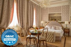 博洛尼亚吉亚巴利奥尼大酒店的酒店客房带一张床、一张桌子和椅子