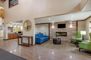 锡达拉皮兹Comfort Inn & Suites Cedar Rapids North - Collins Road的大堂设有蓝色的沙发和壁炉