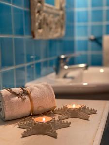 维拉西米乌斯Rokkaria Holidays Apartments的浴室设有2把蜡烛、毛巾和水槽。