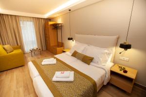 塞萨洛尼基No21 Luxury Suites的酒店客房设有一张大床和一张黄色椅子