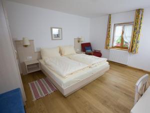 Wildsteig凯博格兰德酒店及客栈的铺有木地板的客房内一张大白色的床