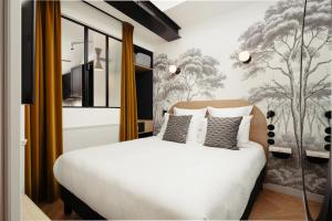 巴黎My Maison In Paris Montmartre的卧室配有白色的床和壁画