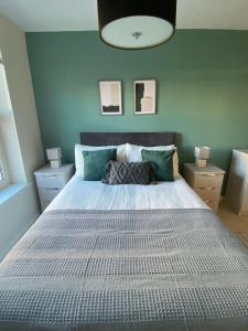 柯科迪Maltings Apartment - Spacious 2 Bed Ground Floor Apartment的卧室配有白色大床和蓝色的墙壁