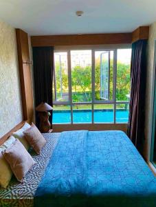 华欣Baan View Viman by PW的一间带大床的卧室和一个游泳池