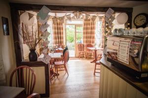 利德尼Swan House Tea Room and Bed & Breakfast的一间带桌椅和时钟的用餐室